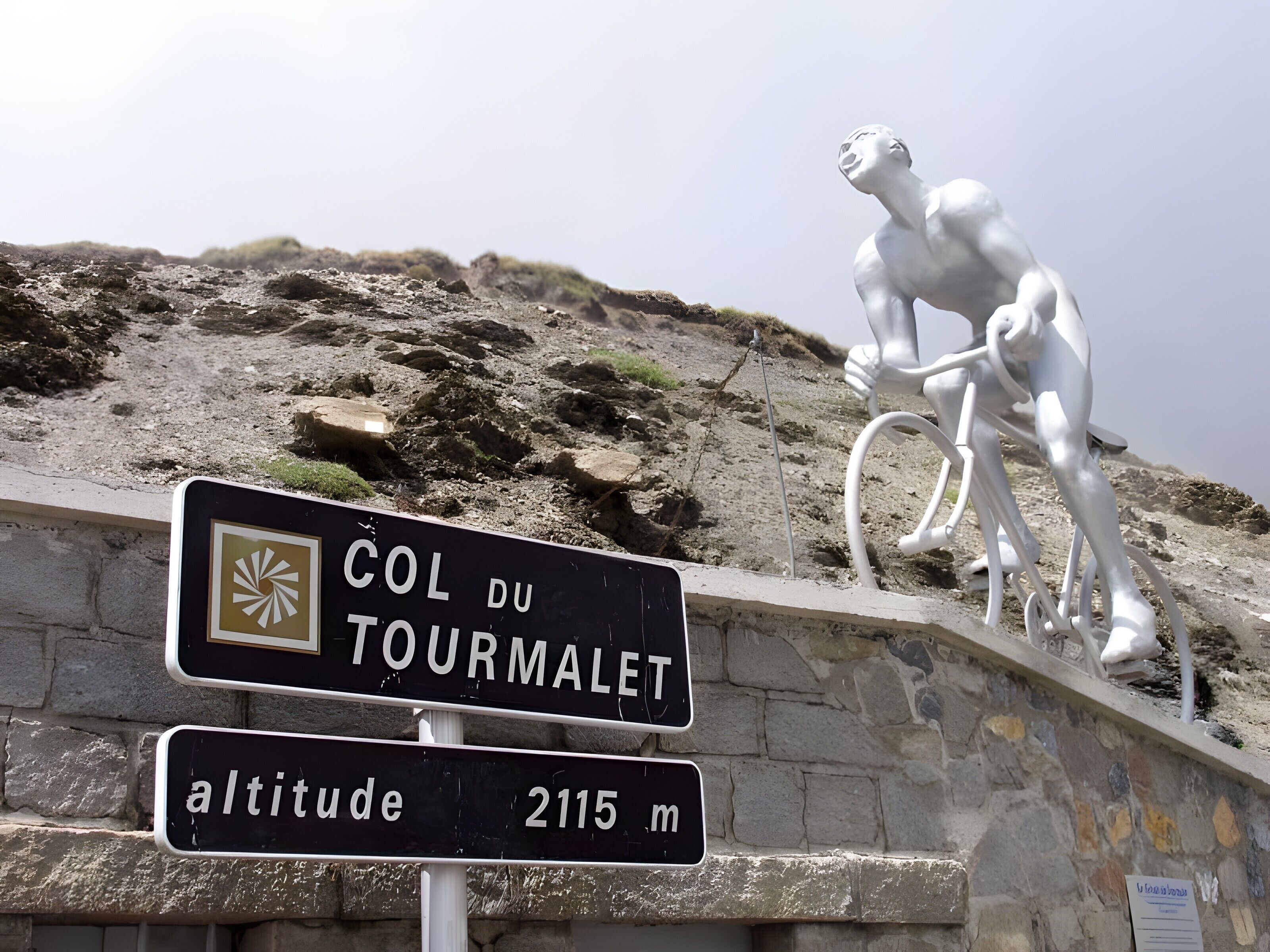 A sign indicating 'COL DU TOURMALET' with an altitude of 2115 m.