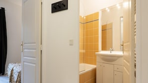 A bathroom with a bathtub, a sink, and a mirror. - Apartment in Grasse Near Restaurants (Grasse)