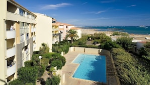 Un hotel con piscina, balconi e vista sulla spiaggia.