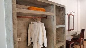 A bathroom with a concrete shelf, a wooden chair, and a mirror. - STC Hotel School (Siem Reap)