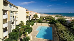 Un hotel con piscina, balcones y vistas a la playa.