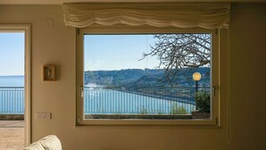 A room with a large window offering a view of a bridge and a body of water.