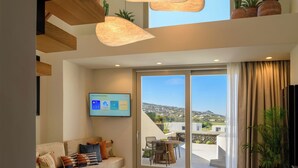 Un salon moderne avec un canapé, une table basse et un téléviseur affichant une application météo.