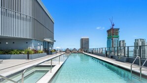 A rooftop pool with a view of the city skyline, including a building under construction. - 501 First Studio with Luxury Amenities (Miami)