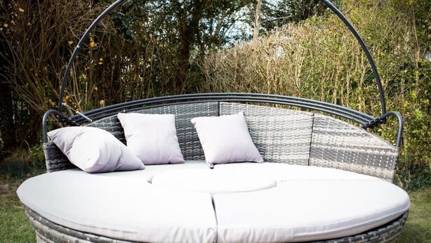 Rottingista punottu ulkotila, jossa on istuinalustoja ja riippuva tukirakenne.