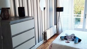 Makuuhuone, jossa on sänky, lipasto, yöpöytälamppu ja näkymä ulos.