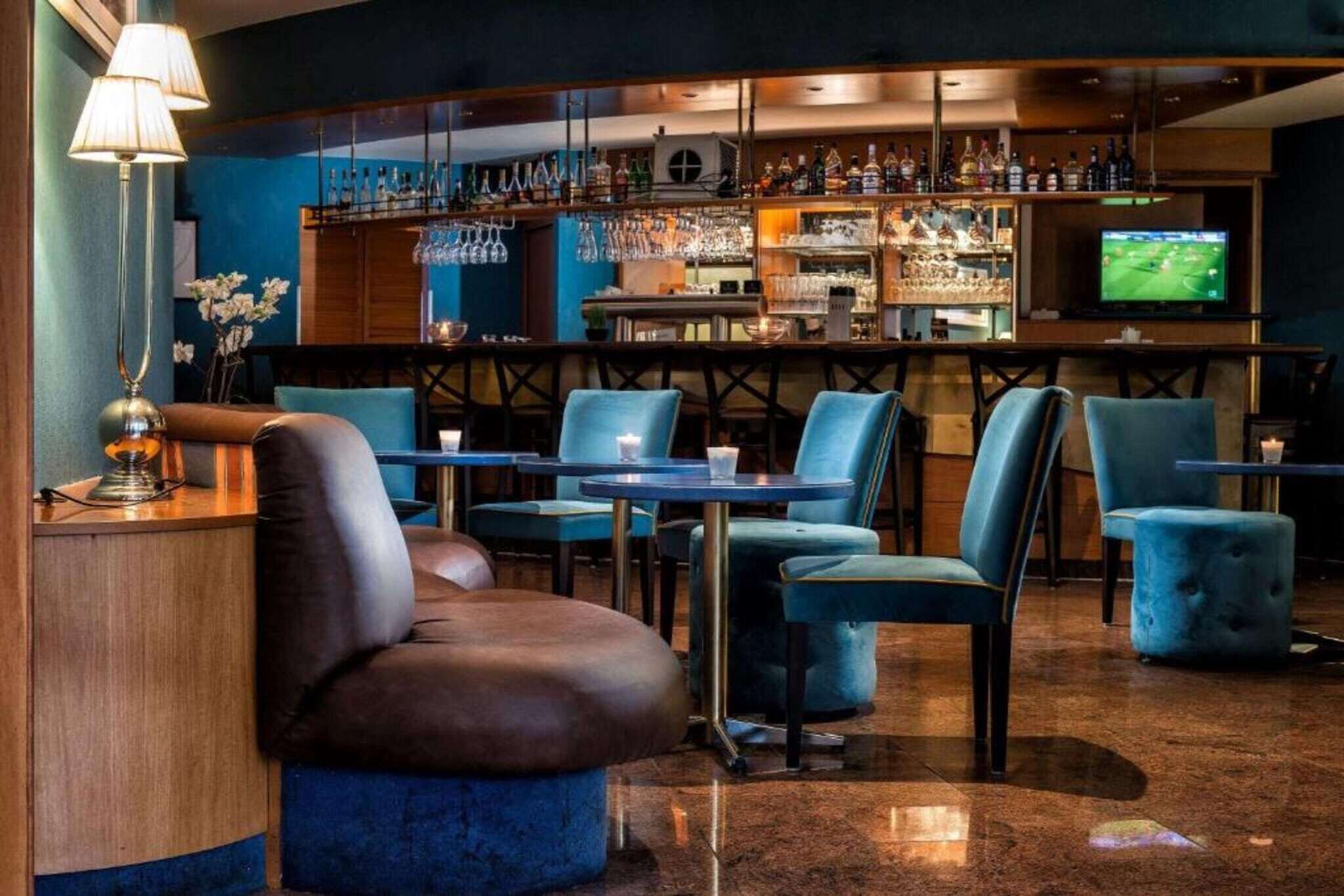 Eine Bar mit Sitzgelegenheiten, einem Fernseher und einer Auswahl an Flaschen.
