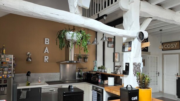 A kitchen with a bar area, a clock, and a sign that says 'Milan, Paris.' - Charming Air-Conditioned House –Pyrenees Views, Tennis & Large Garden (Sleeps 8) (Uzan)