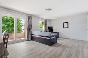 A bedroom with a bed, a TV, and a balcony with curtains. - Functional Holiday Base in Grasse (Grasse)