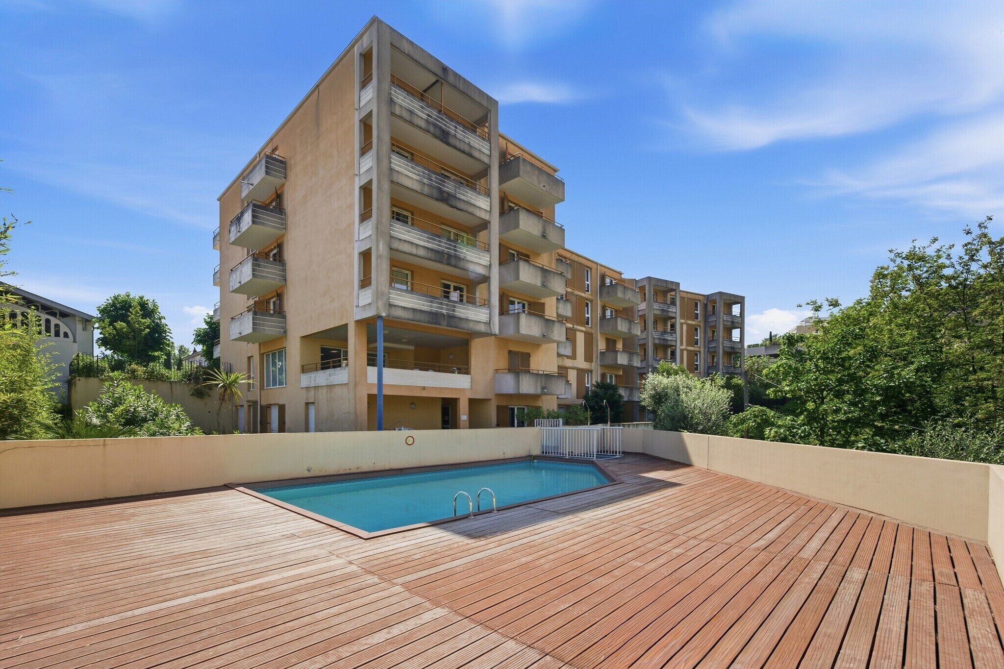 Un immeuble résidentiel à plusieurs étages doté d’une piscine sur le toit.