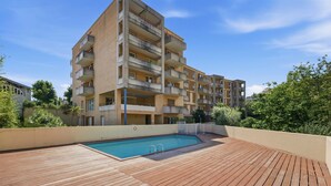 Un immeuble résidentiel à plusieurs étages doté d’une piscine sur le toit.