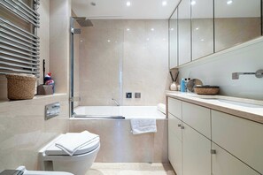 Ein modernes Badezimmer mit Badewanne, Toilette und Dusche.