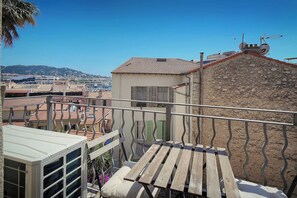 A balcony with a view of a cityscape, a stone wall, and a metal railing. - Stunning Apartment a/c 6P with Sea View - Cannes (Cannes)