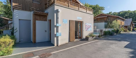 A building with a reception area, a wooden balcony, and a sign indicating a 10-minute walk to a ski lift.
