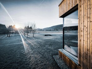 A modern building with a wooden exterior and a large window. - New build and traditional house below Lausche (Großschönau)