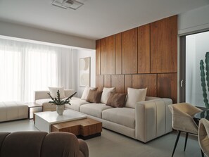 Una sala de estar moderna con un sofá, una mesa de centro y una pared de madera decorativa.