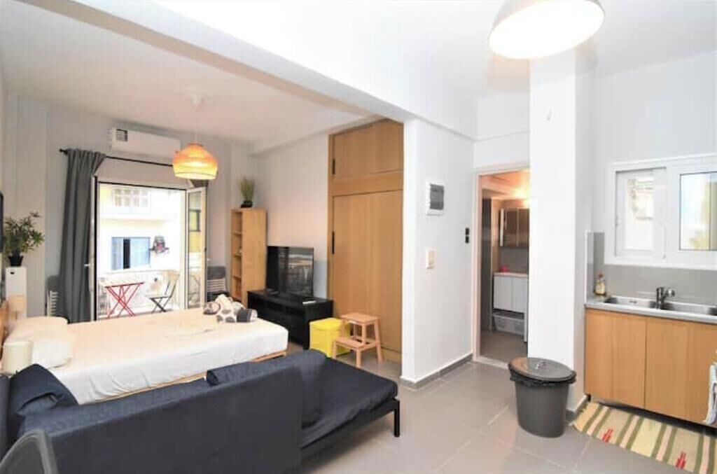 Ein gemütlicher Wohnbereich mit Bett, Schlafsofa, Küchenzeile und Essplatz.