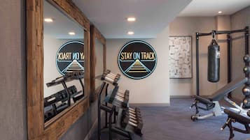 A home gym with exercise equipment, including dumbbells, a bench, and a punching bag.