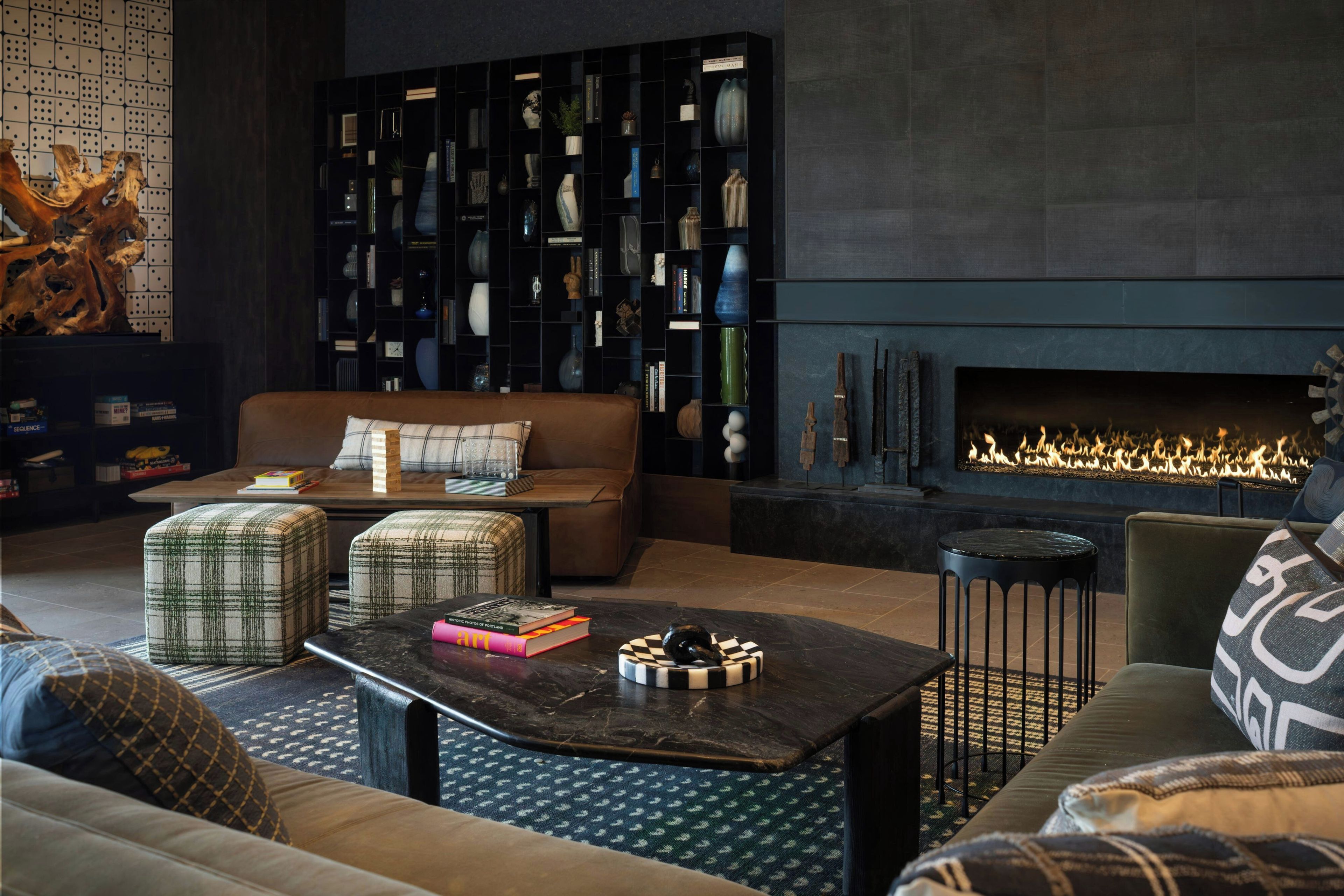 A modern living room with a fireplace, a sofa, ottomans, and a coffee table.