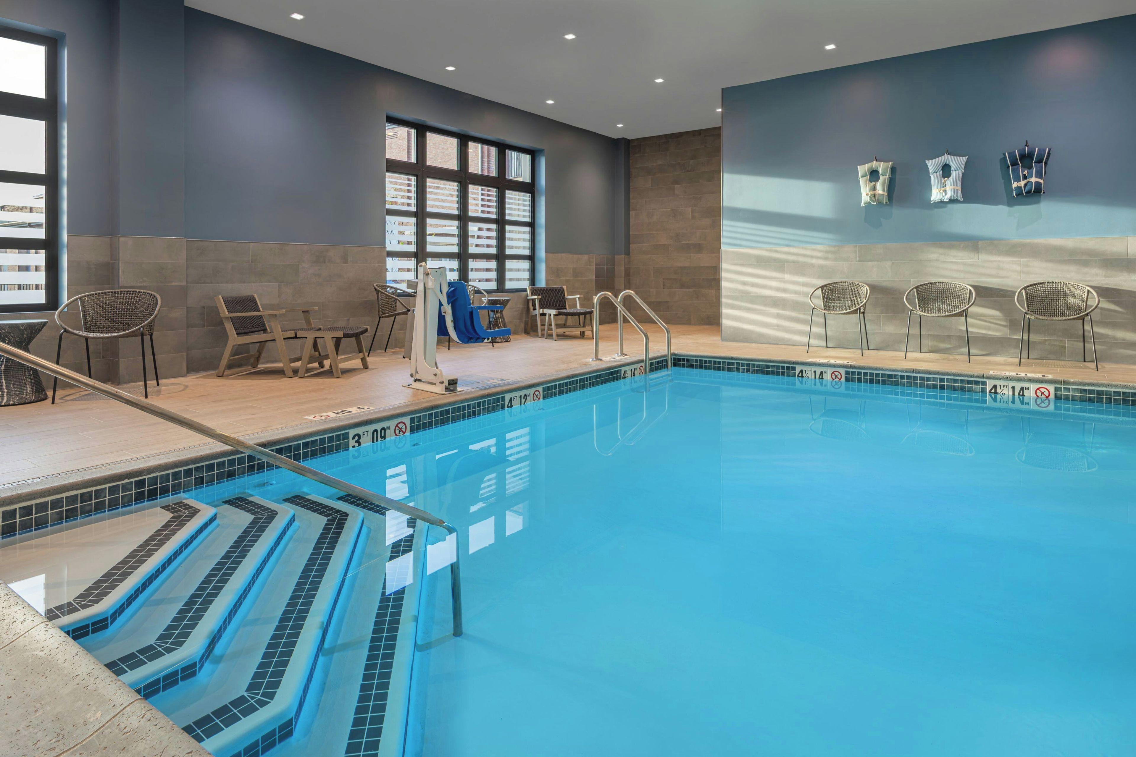 Una piscina interior con agua cristalina, marcas de profundidad y borde de azulejos.