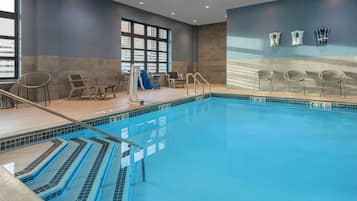 Una piscina interior con agua cristalina, marcas de profundidad y borde de azulejos.