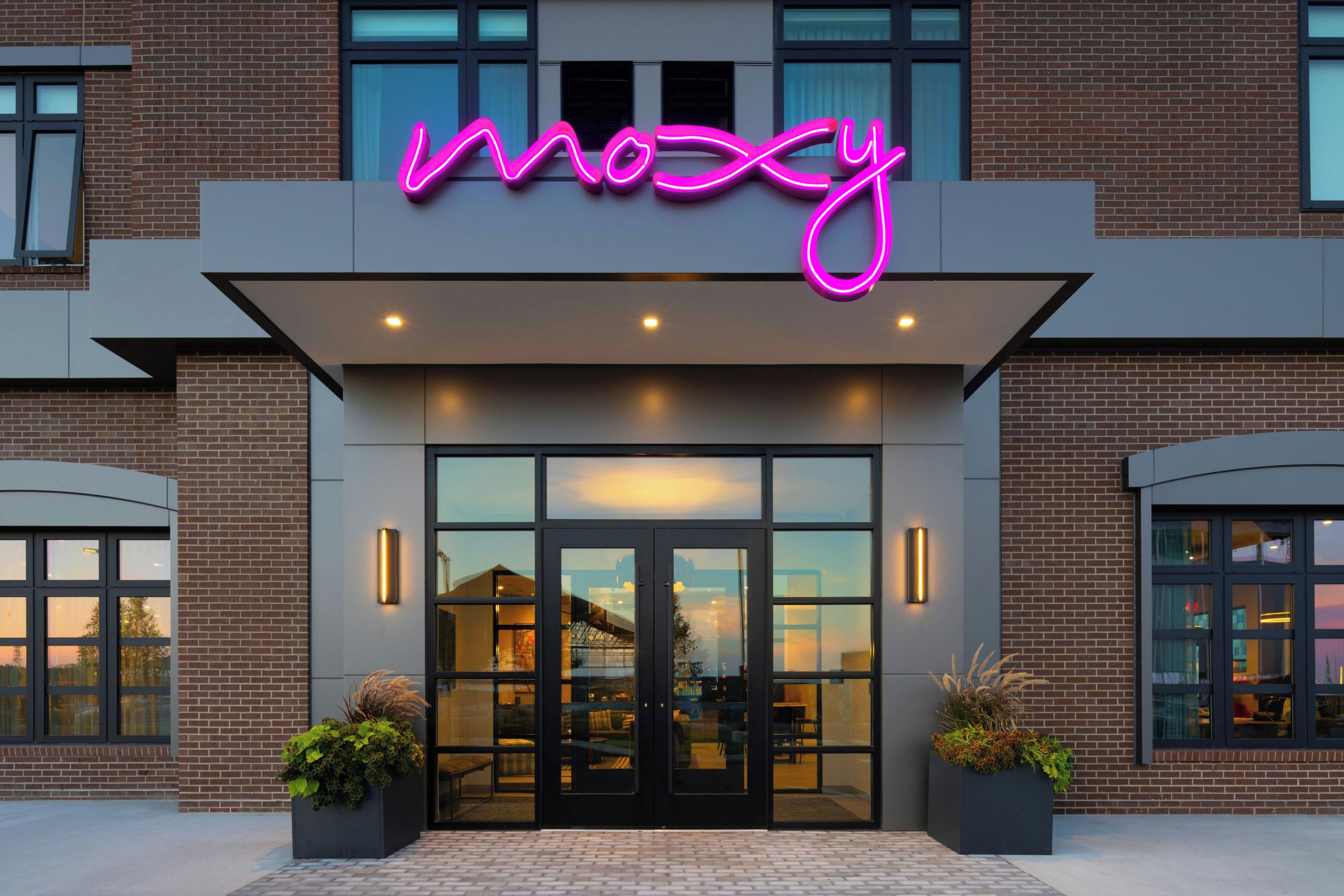 A modern building with a neon sign reading 'moosy' above the entrance.