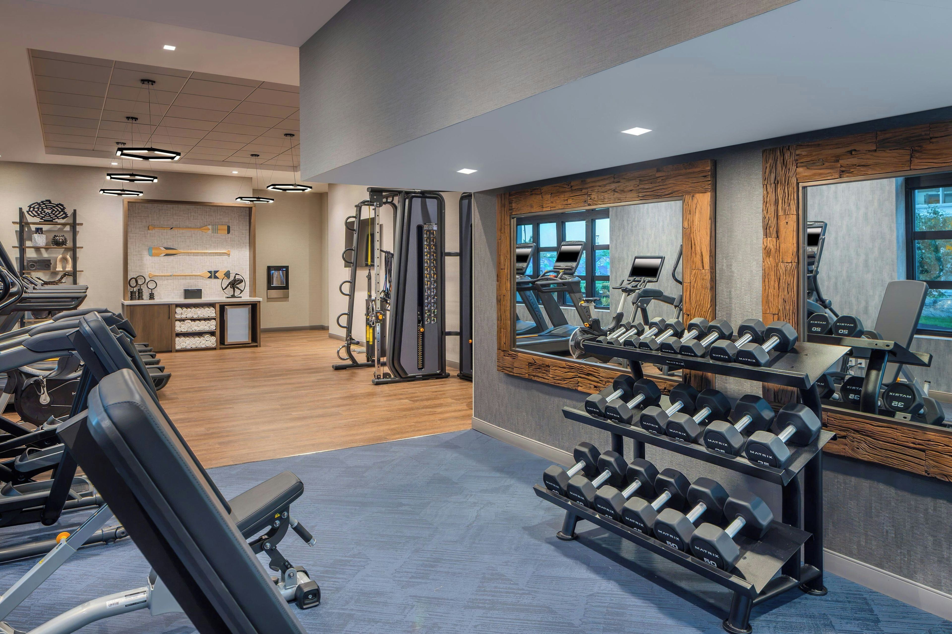 A gym with treadmills, weight benches, and dumbbells.