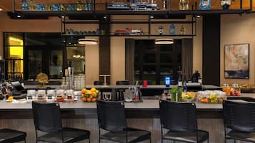 A bar area with multiple seating options, a variety of glassware, and a display of model trains.
