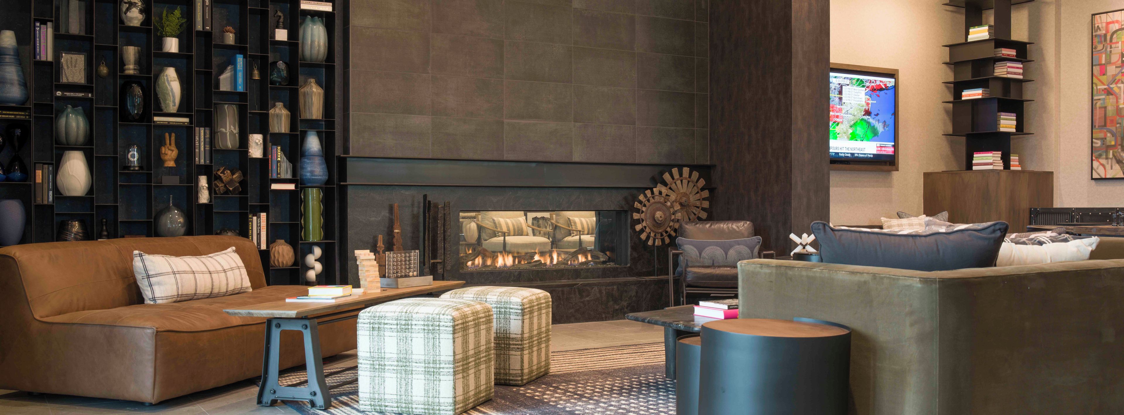 A modern living room with a fireplace, a bookshelf, and a television.
