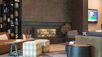 A modern living room with a fireplace, a bookshelf, and a television.