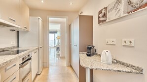 A modern kitchen with granite countertops, stainless steel appliances, and a coffee maker on the counter. - Apartment 'Ocean Vista Calaceite' with Sea View, Swimmingpool and South-facing terrace (Torrox Costa)