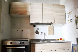 Eine Küche mit Holzausstattung, einem Edelstahlspülbecken und einem Herd.