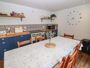 Eine Küche mit Herd, Mikrowelle und Holzschränken.