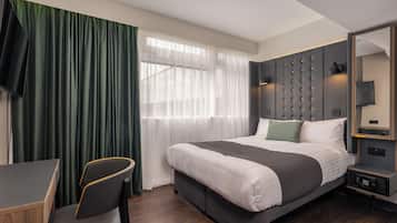 Una habitación de hotel moderna con una cama grande, un escritorio y una silla.