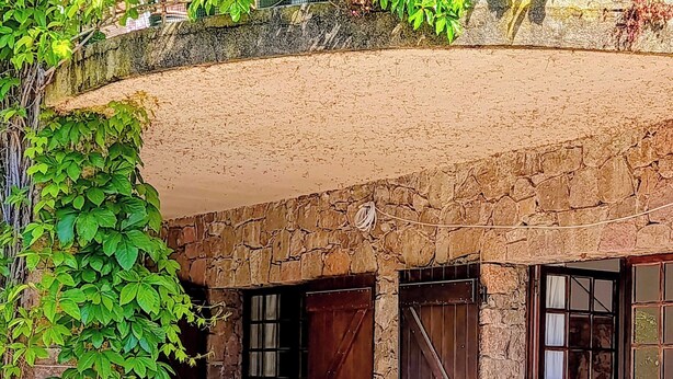 A rustic stone building with a covered patio, a table with chairs, and a potted plant. - Garden apartment in the countryside near the sea pets welcome (Les Adrets-de-l'Estérel)