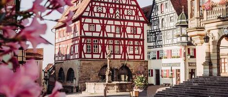 A traditional half-timbered building with a courtyard and cobblestone ground.