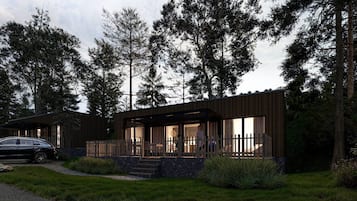 Une maison moderne à deux étages, dotée d’un porche abrité et d’une voiture garée devant.