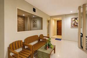A modern living room with a sofa set, a coffee table, and a large mirror. - Hotel O near Balikpapan International Airport formerly Barkah Guest House (Balikpapan)