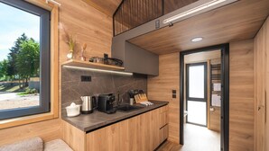 Une cuisine moderne dotée d’un plan de travail en bois, d’une machine à café et d’une bouilloire.