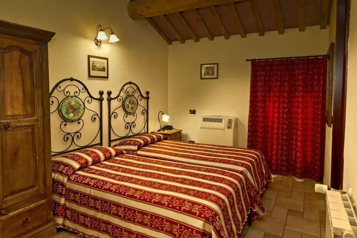 Un dormitorio con cama, armario de madera, luminarias empotradas en la pared y un radiador.