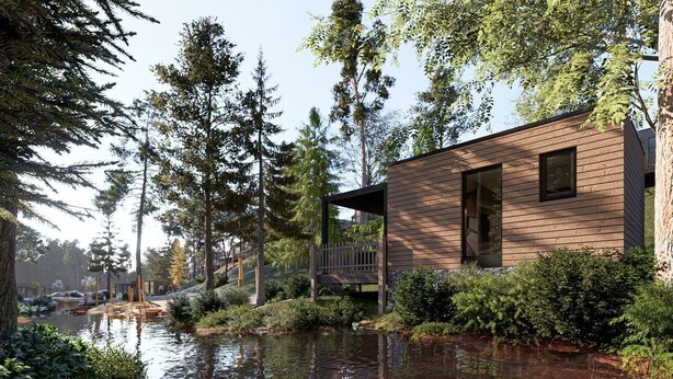 A cabin with a deck, surrounded by trees and a body of water.
