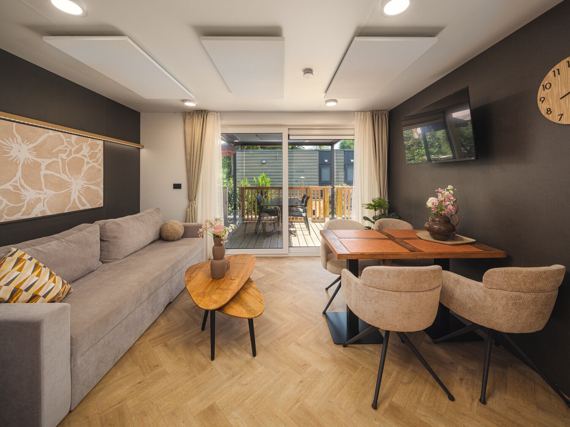 A modern living room with a sofa, a coffee table, and a dining area with chairs and a table.