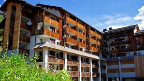 A multi-story hotel with balconies, a covered terrace, and a garden area. - 4-guest Studio With Mountain View (Orcieres)