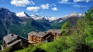 A mountain village with wooden buildings, a valley, and snow-capped peaks. - 4-guest Studio With Mountain View (Orcieres)