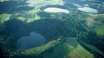 An aerial view of a landscape with multiple ponds surrounded by forested areas and agricultural fields.