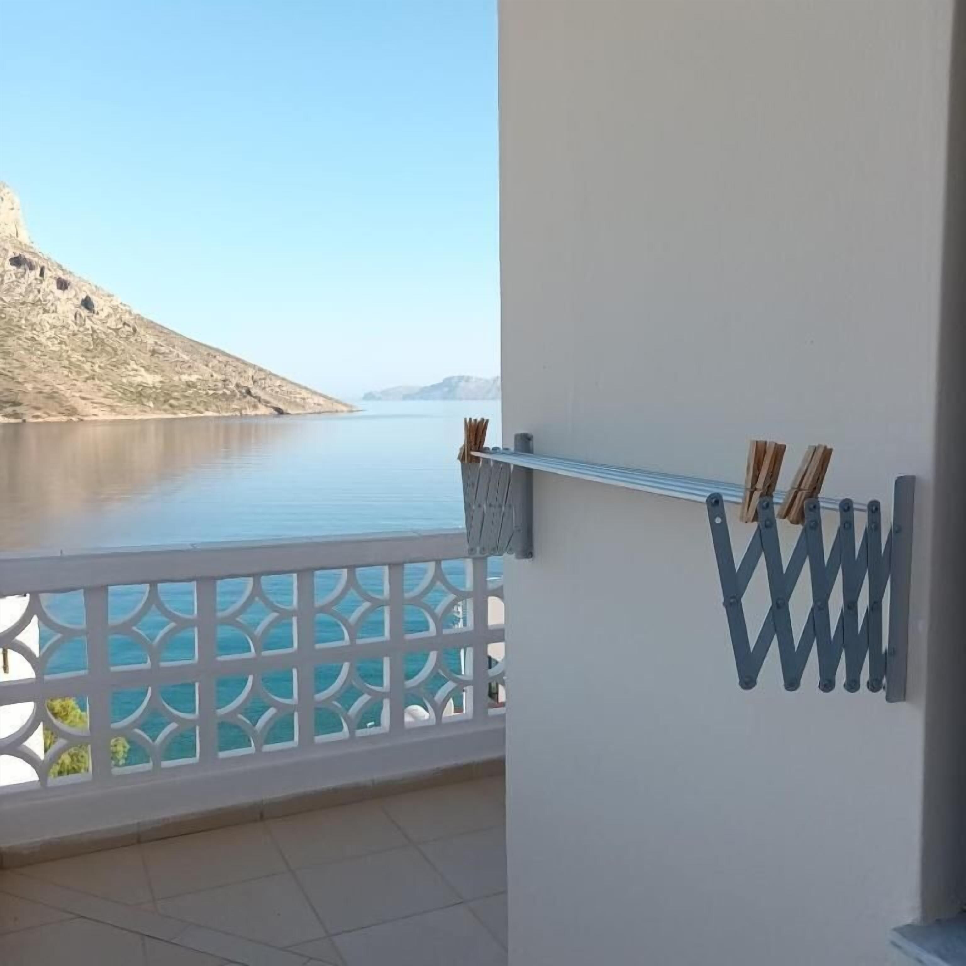 Ein Balkon mit Blick auf ruhiges Wasser und eine entfernte Küste.