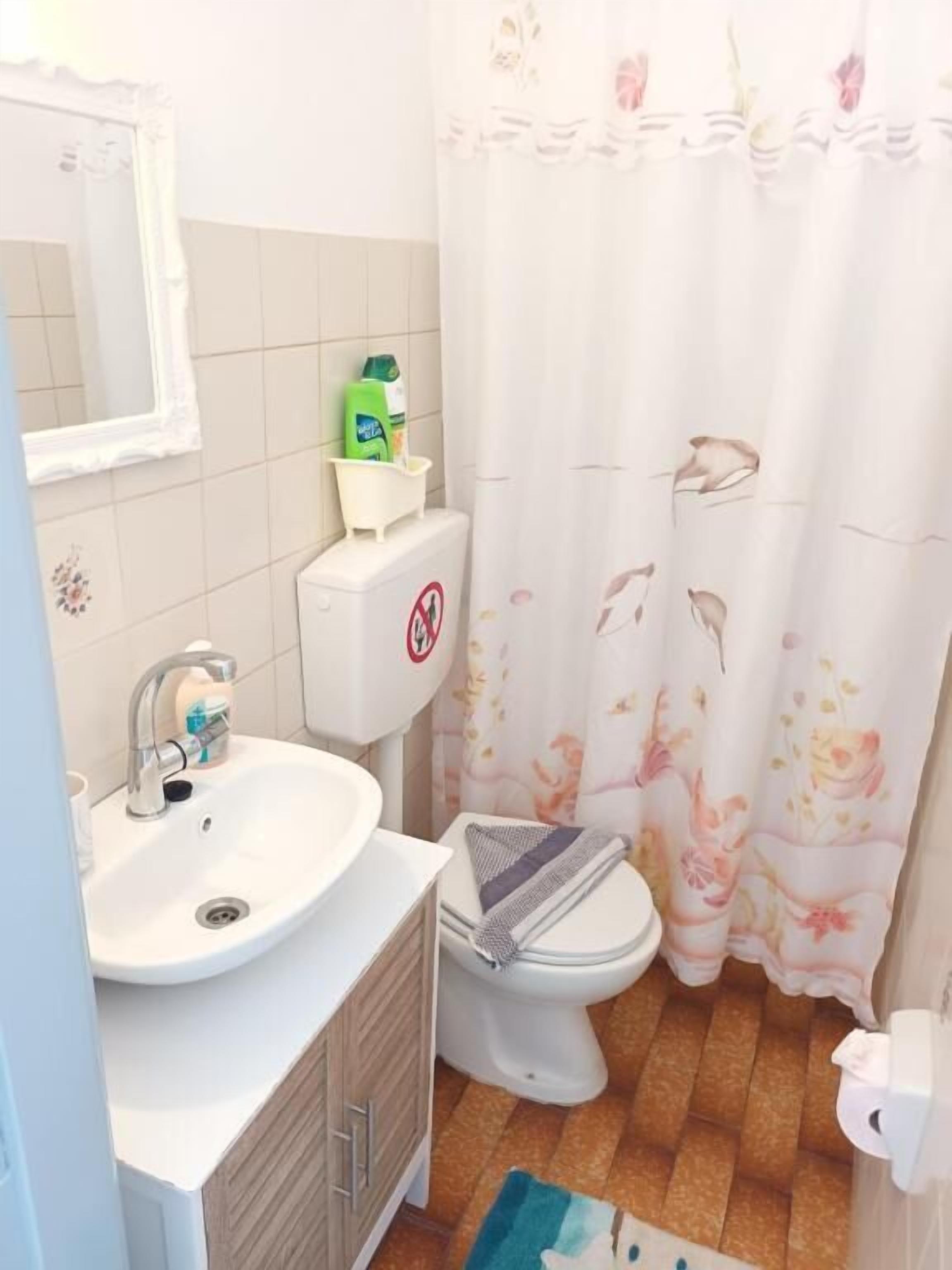 A bathroom with a sink, toilet, and shower curtain.