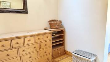 A wooden dresser with drawers, a wicker basket, and a wicker basket on a shelf.