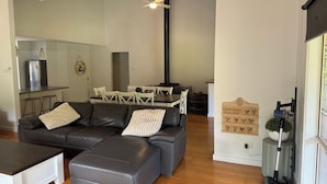 Una sala de estar moderna con un sofá modular, una mesa de centro y un comedor con sillas y una mesa.