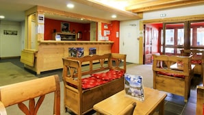 A wooden interior with a reception desk, wooden benches, and tables. - Family Apartment in La Foux D'allos (Allos)